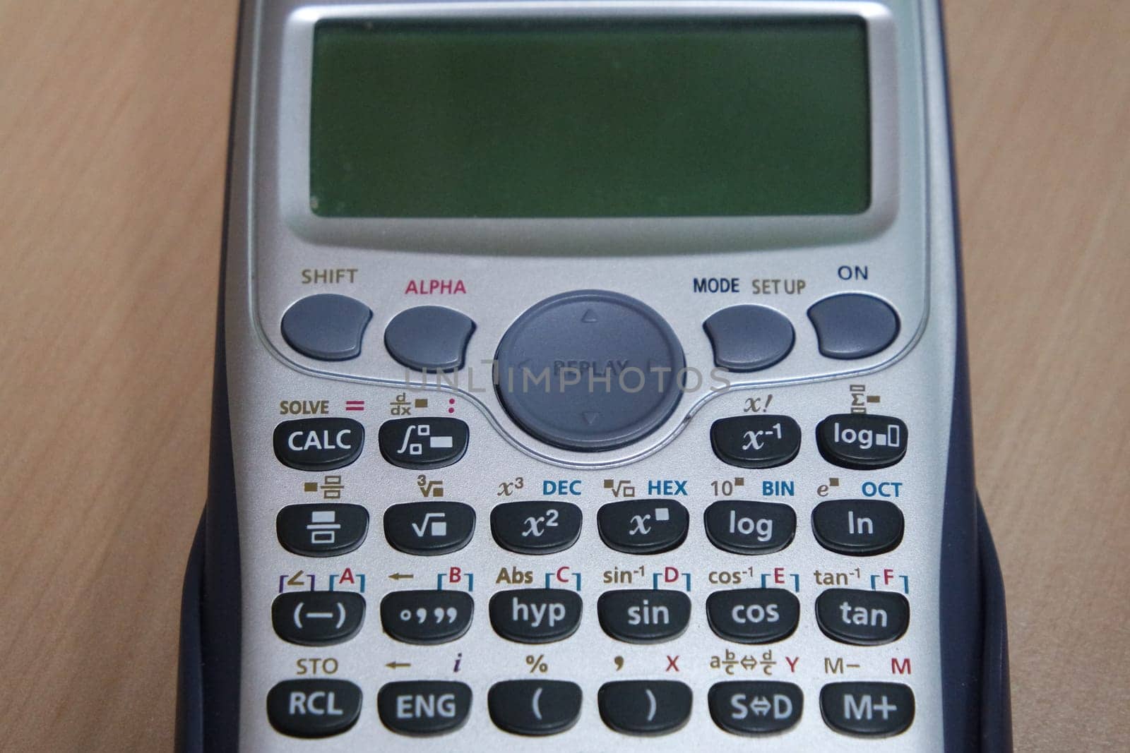 Calculator with colored keys or buttons isolated on a wooden background