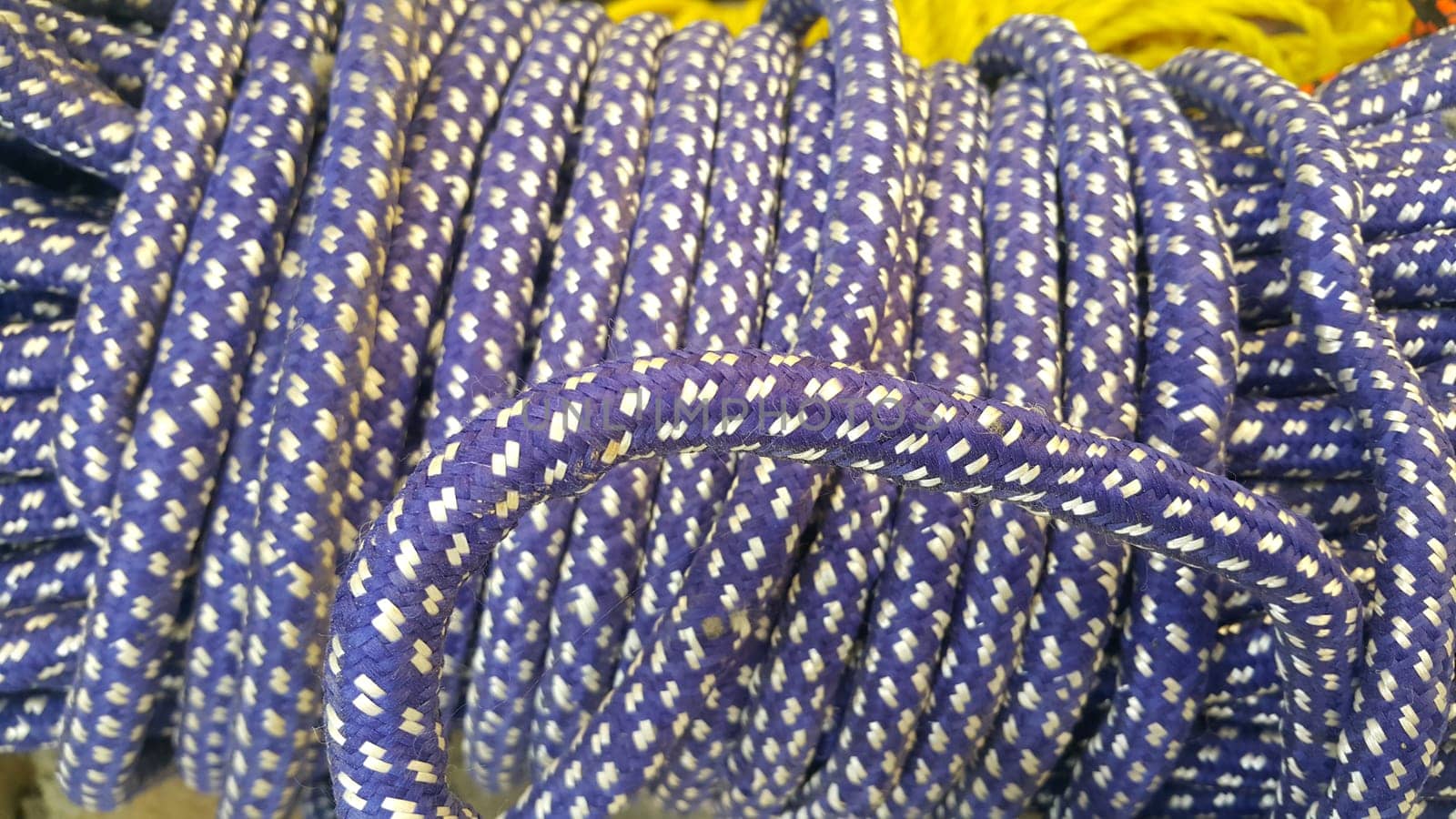 Closeup of bright color braided plastic ropes. Hanks or coil of bright colored plastic rope interwoven which are used for climbing and tightening materials.