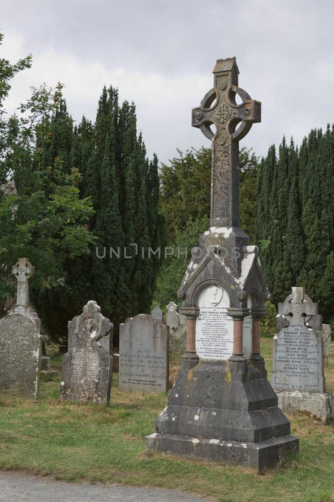 Glendalough, co. Wicklow, Ireland - August 10 2019 :Stone round tower and some ruins of a monastic settlement originally built in the 6th century in Glendalough valley, County Wicklow, Ireland.