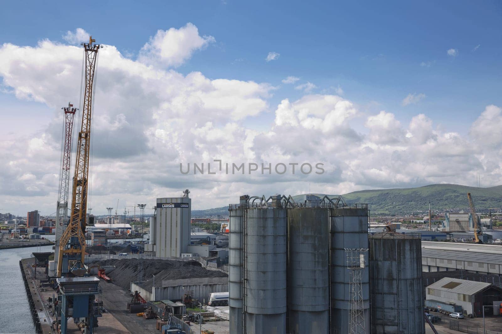 Belfast, Northern Ireland - June 9, 2017:  A view across Belfasts dockland from HMS Caroline in the Titanic Quarter with Carrs glen and Napoleon's Nose in the background.Belfast, UK