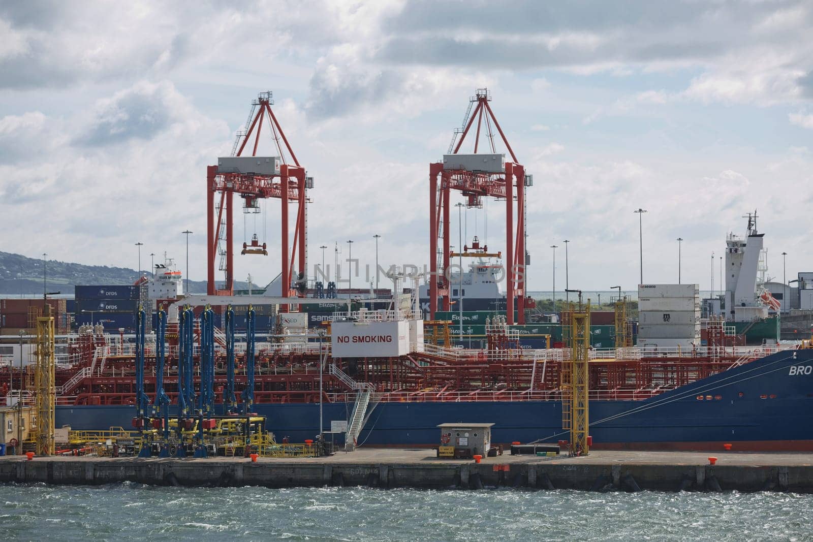 Dublin, Ireland - June 6, 2017: Large industrial cranes loading container ship in Dublin Port in Ireland.