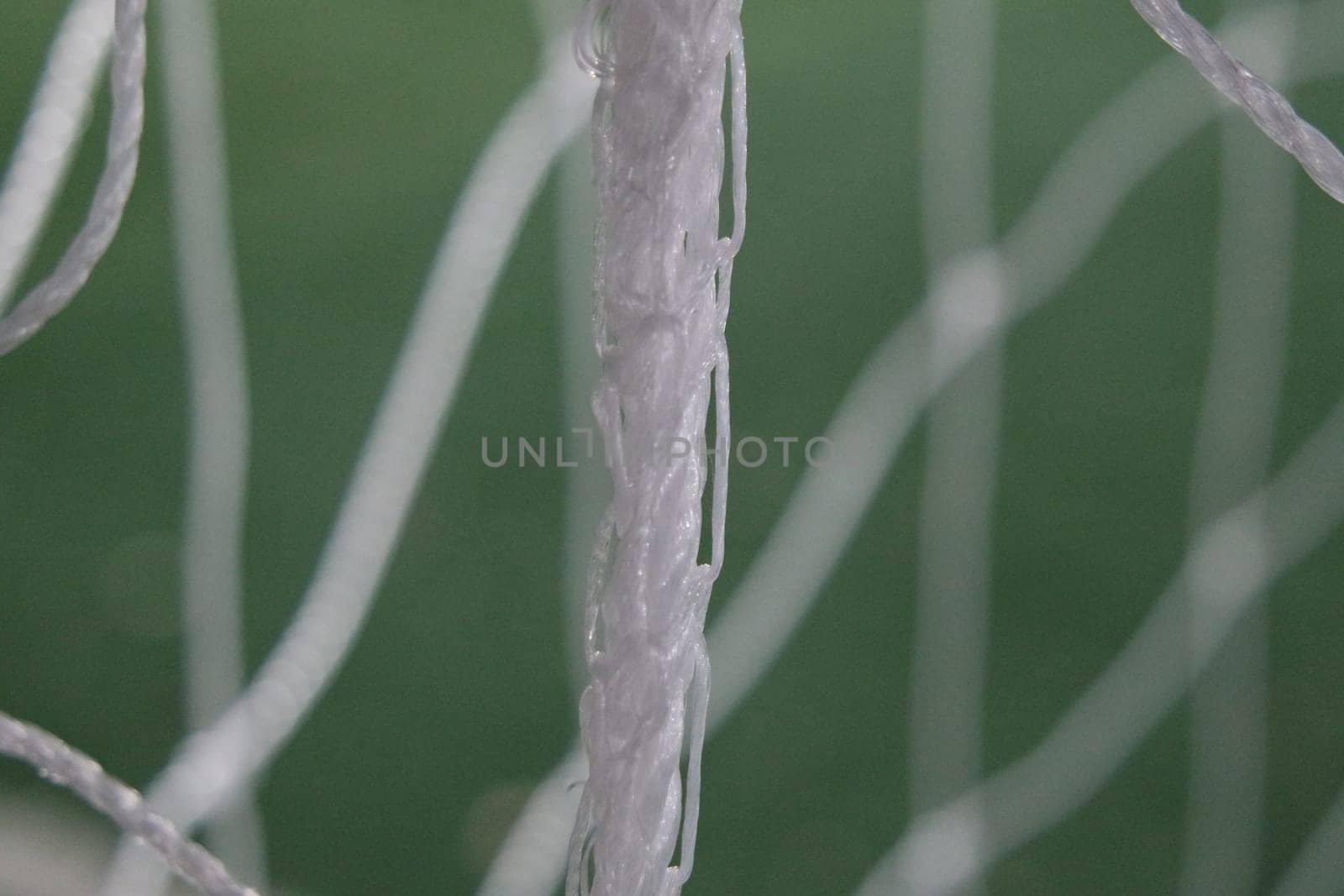Night view of a soccer goal net under flood lights. Closeup view of goal net in a soccer playground