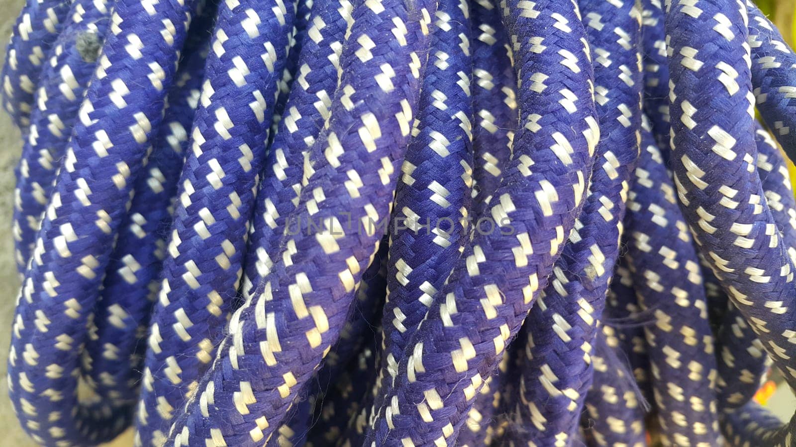 Closeup of bright color braided plastic ropes. Hanks or coil of bright colored plastic rope interwoven which are used for climbing and tightening materials.