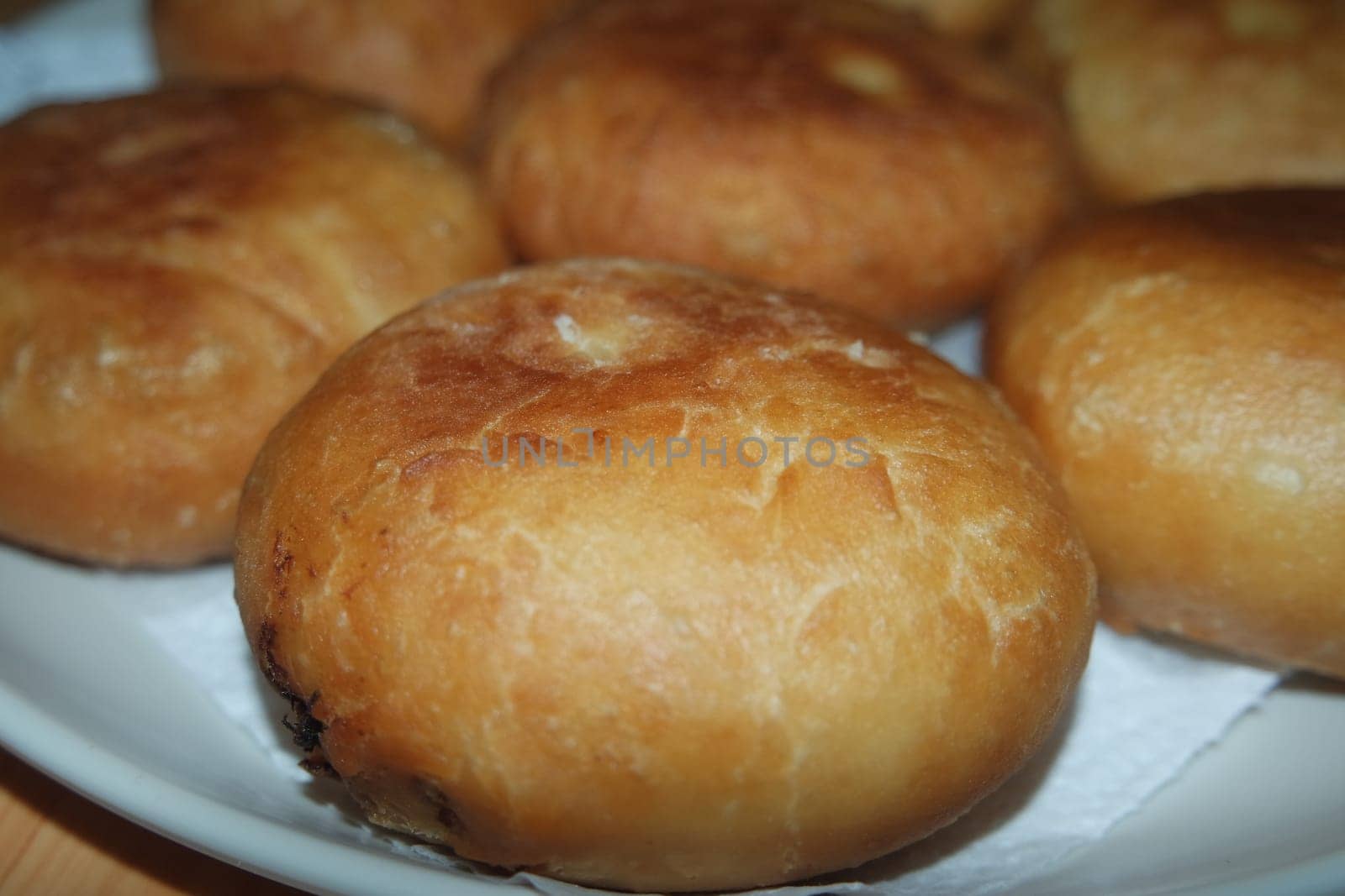 Closeup view of homemade tasty potato bread rolls bun placed over white tissue paper.