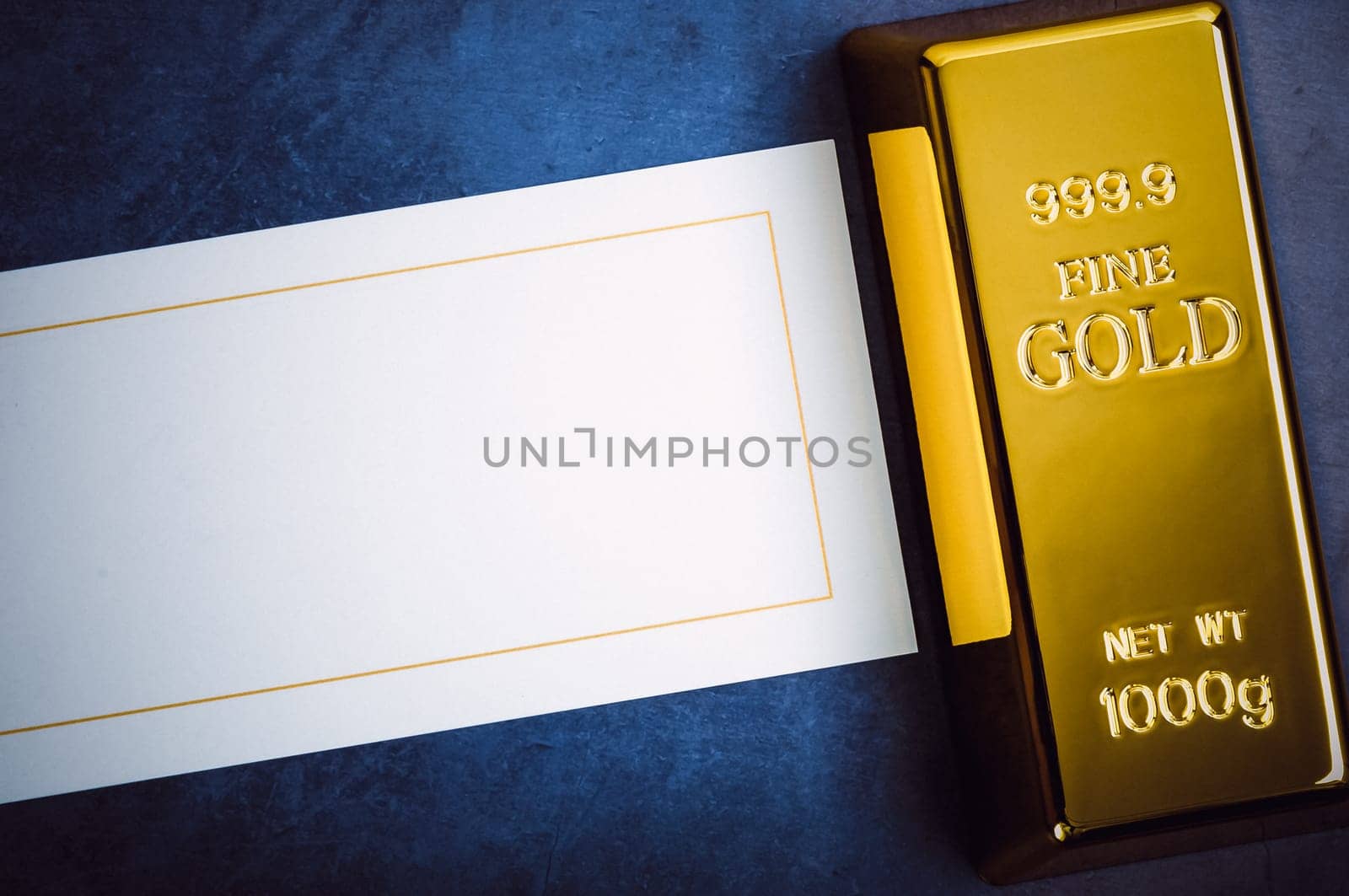 An ingot of gold metal bullion of pure brilliant diagonally located on a blue textured background