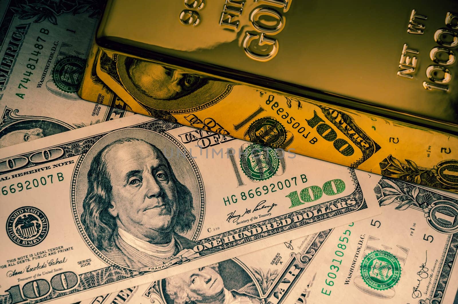 Gold metal ingot on the background of dollar bills