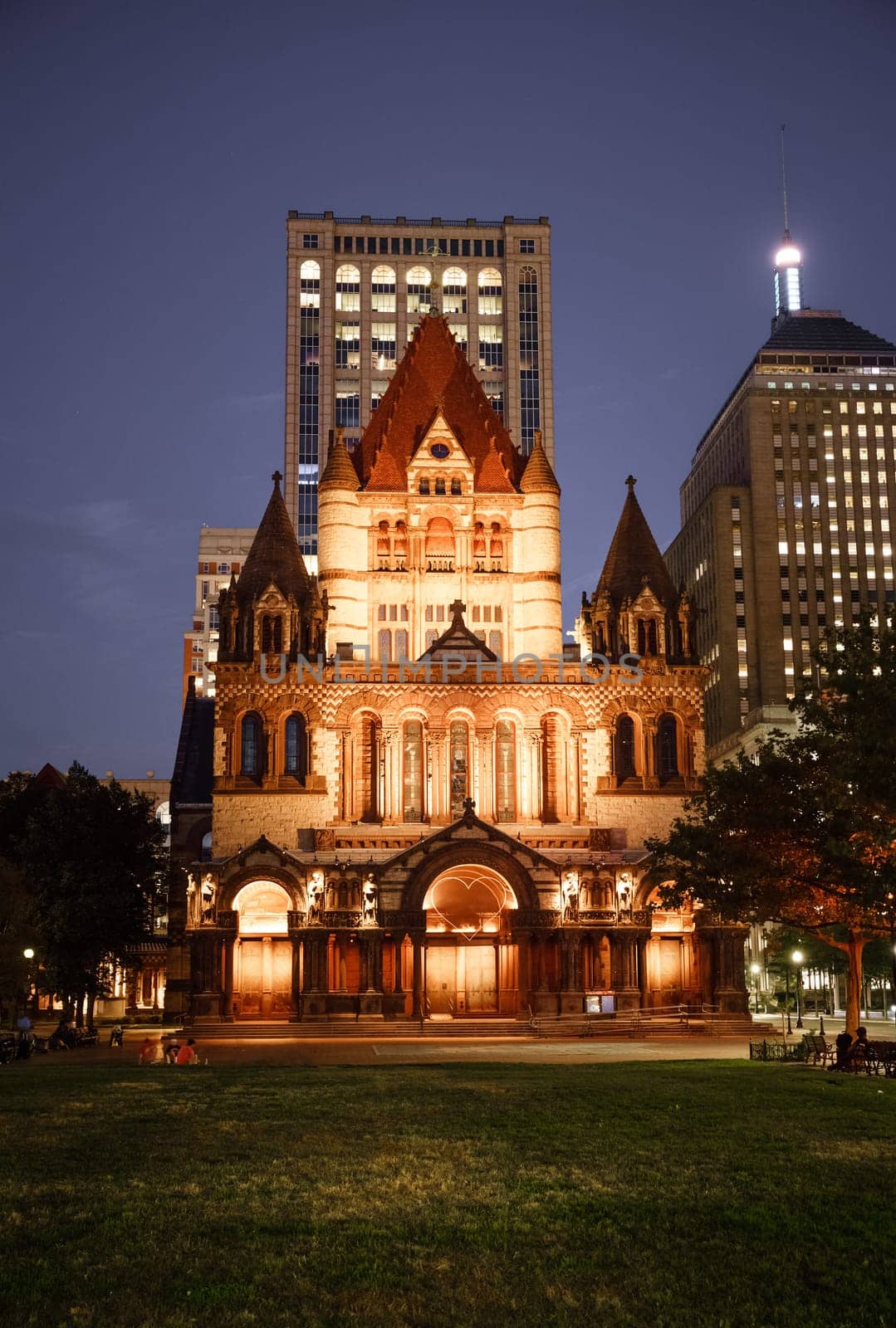 Nighttime view of historic Trinity Church in downtown Boston