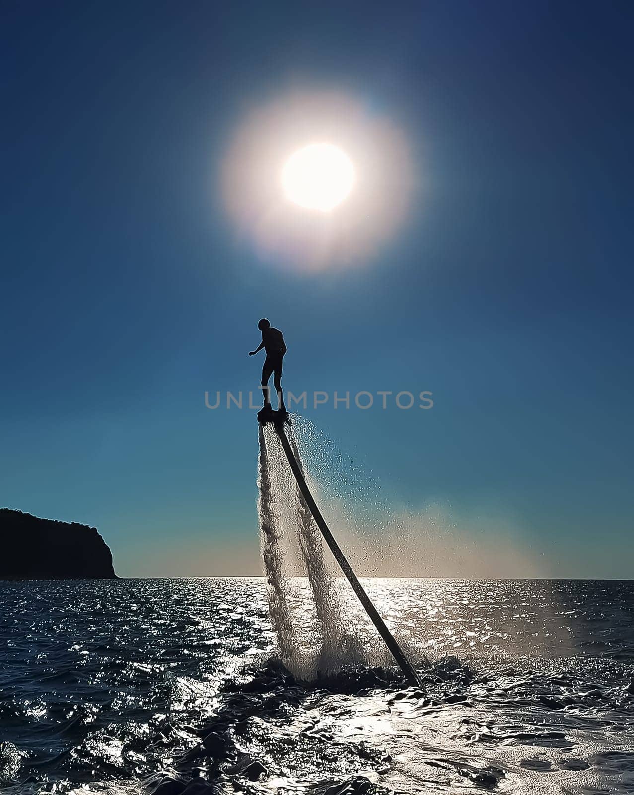 The man on the flyboard. Sea fun by the shore.