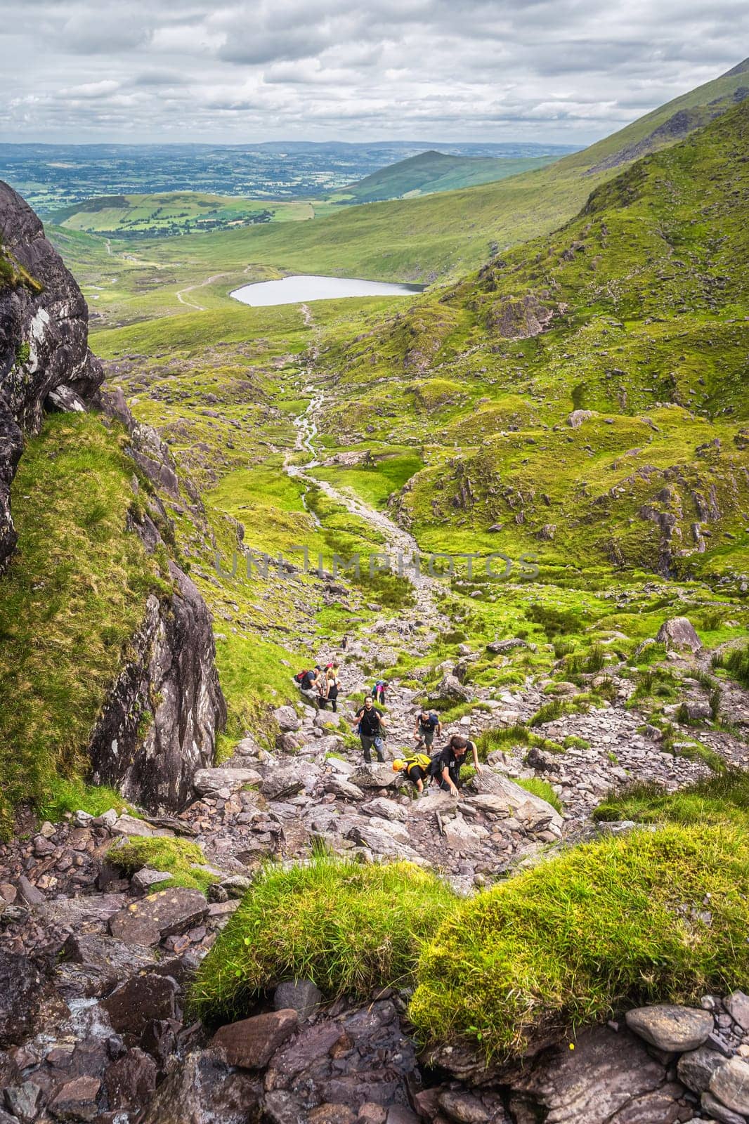 Killarney, Ireland, July 2019 Group of hikers climbing Devils Ladder, difficult trail, to reach highest Irish mountain Carrauntoohil, Ring of Kerry