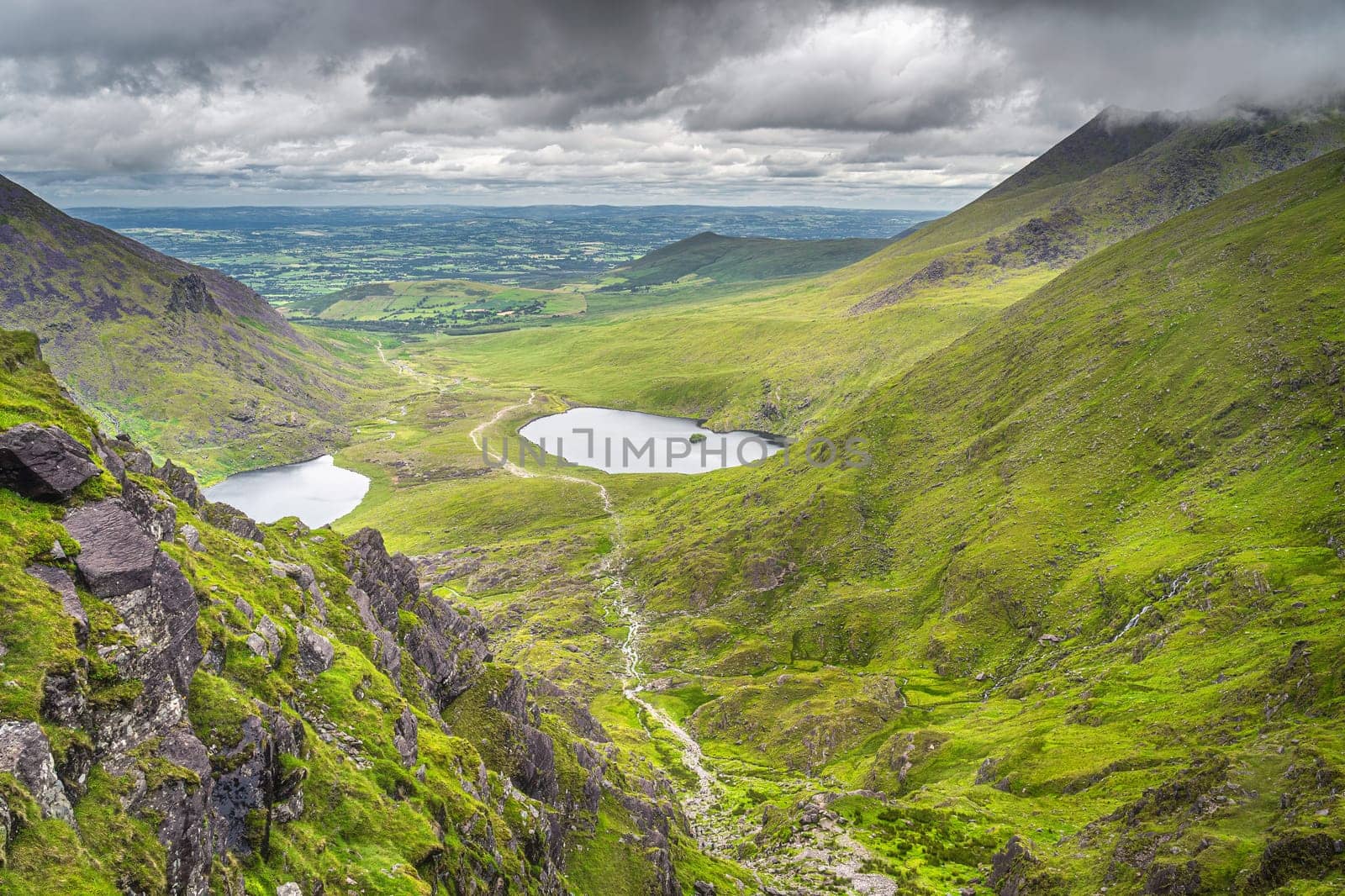 Group of hikers climbing Devils Ladder, one of most difficult trails, to reach highest Irish mountain Carrauntoohil in Ring of Kerry, Ireland