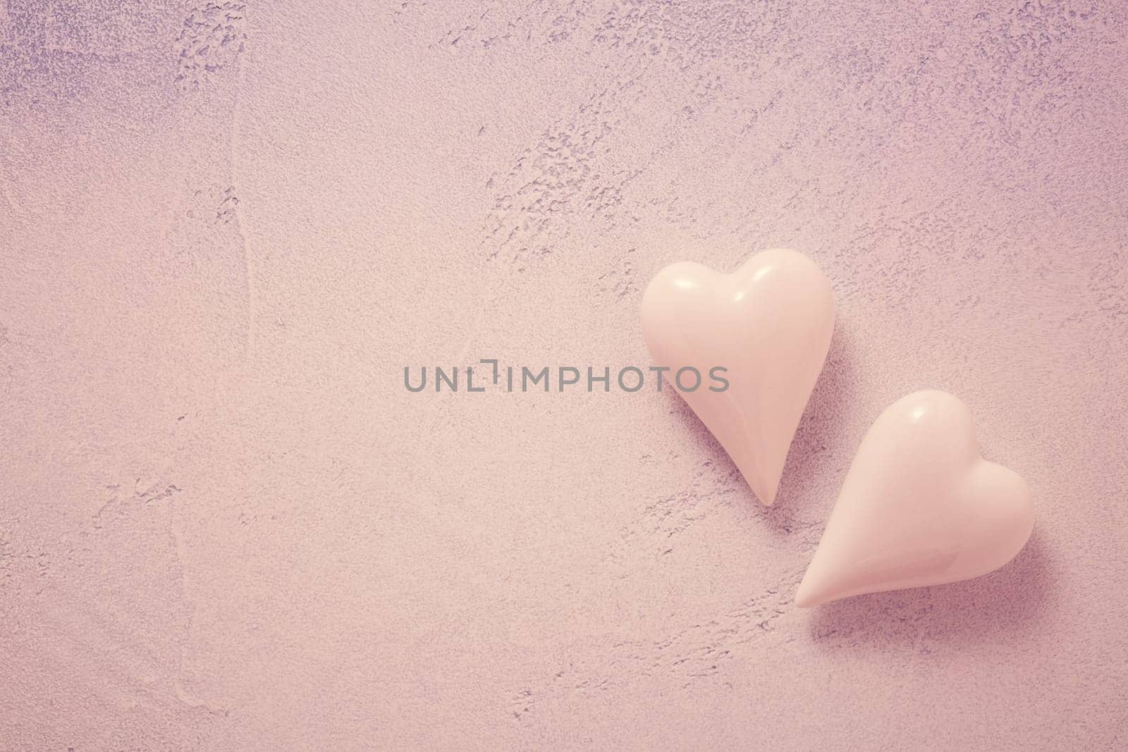 Two glass hearts on stone background in vintage pastel colors - soft focus. Symbol of love. Space for text.