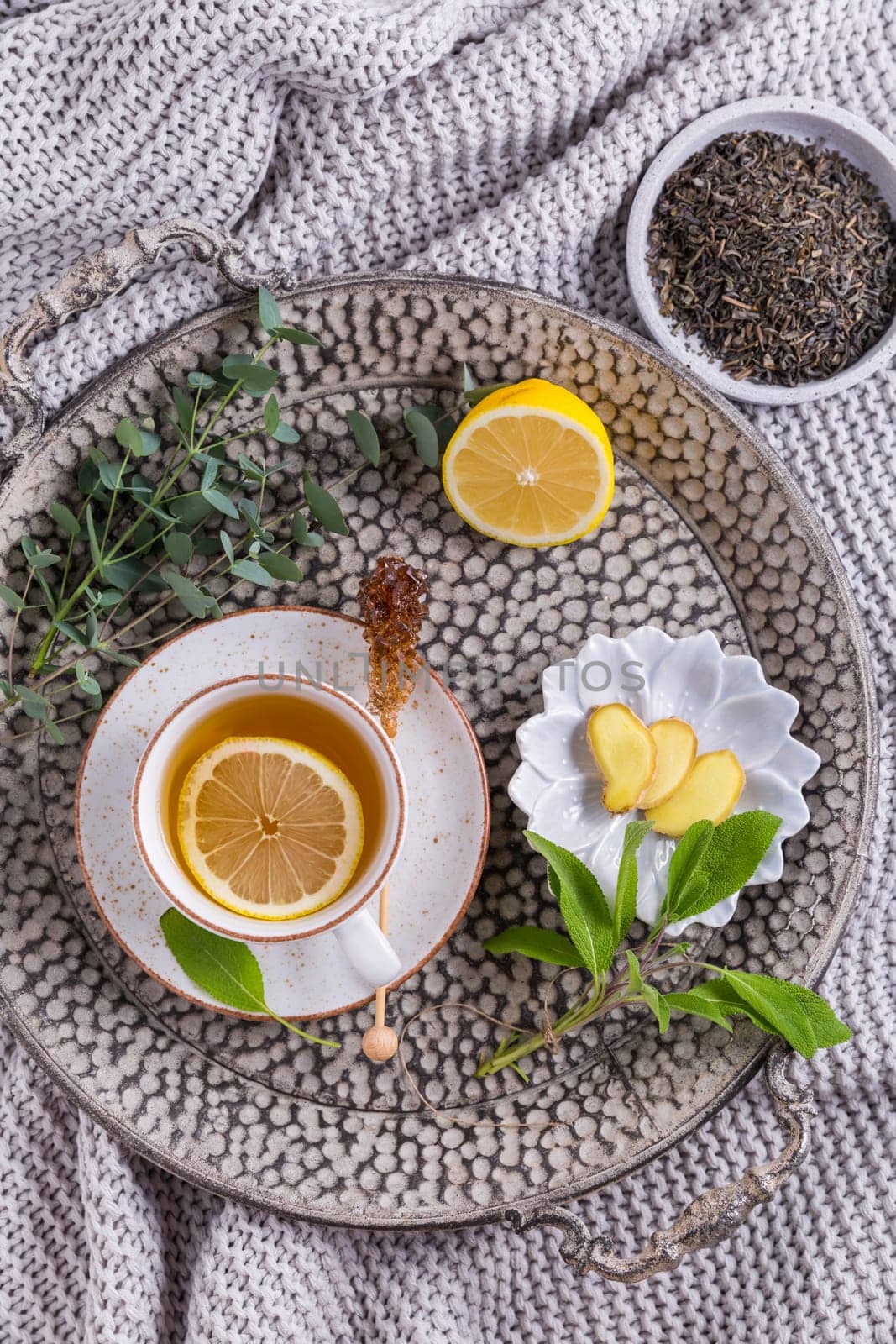 Healthy detox ginger and sage tea with lemon on tray
