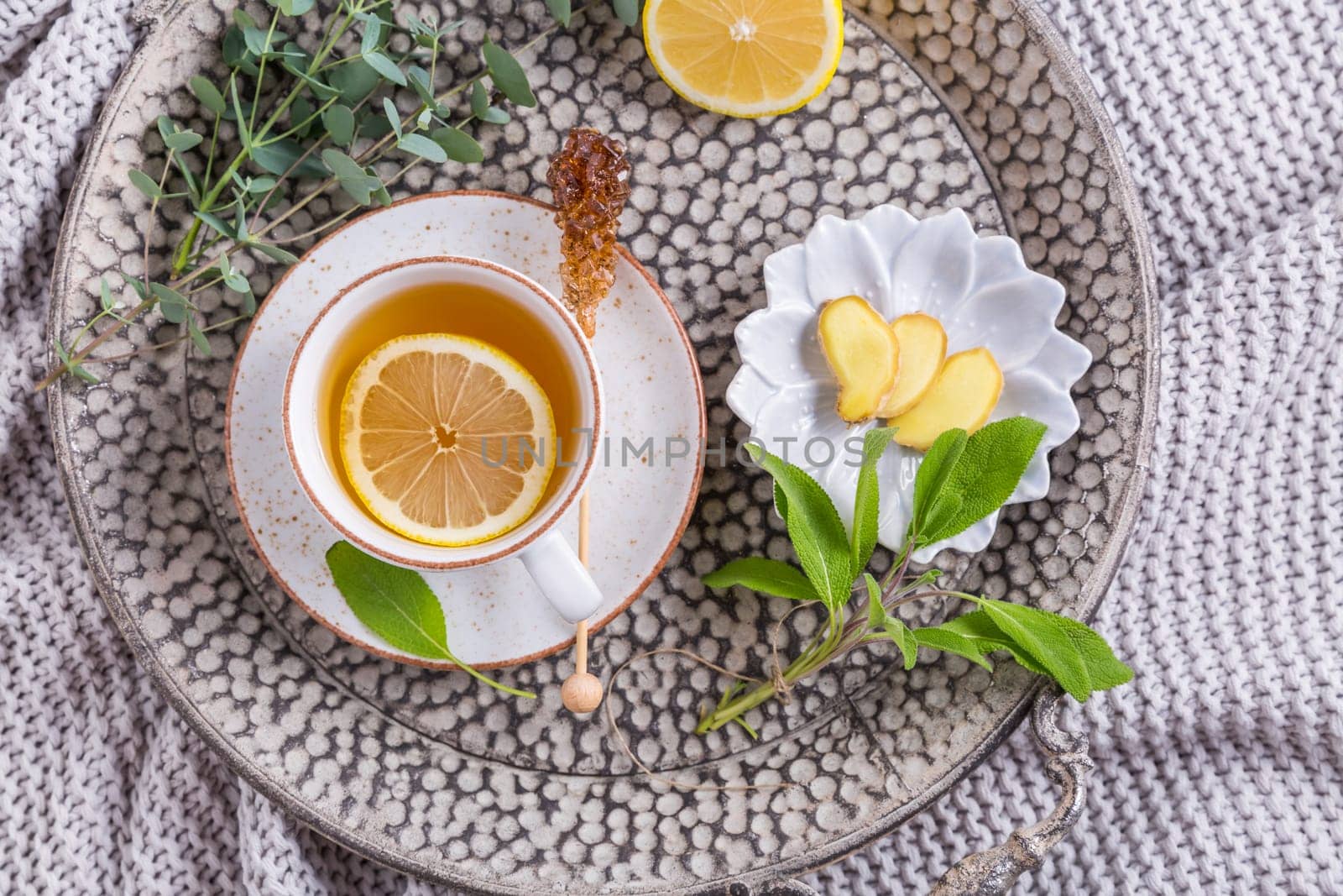 Healthy detox ginger and sage tea with lemon on tray