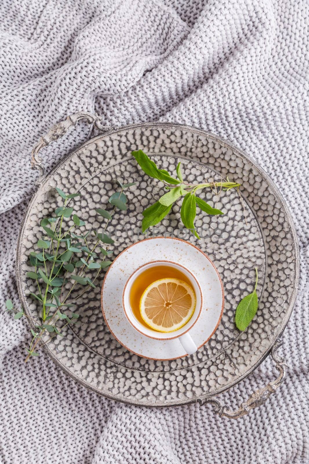 Healthy detox ginger and sage tea with lemon on tray