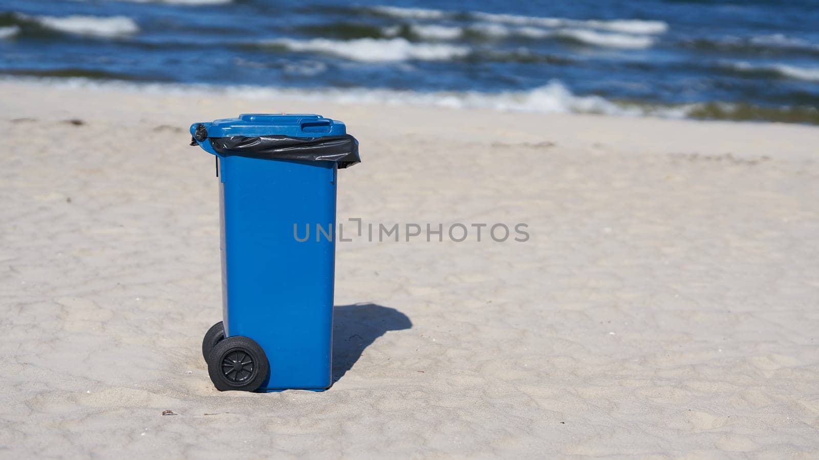 blue garbage can on the beach of Swinoujscie on the Polish Baltic Sea coast