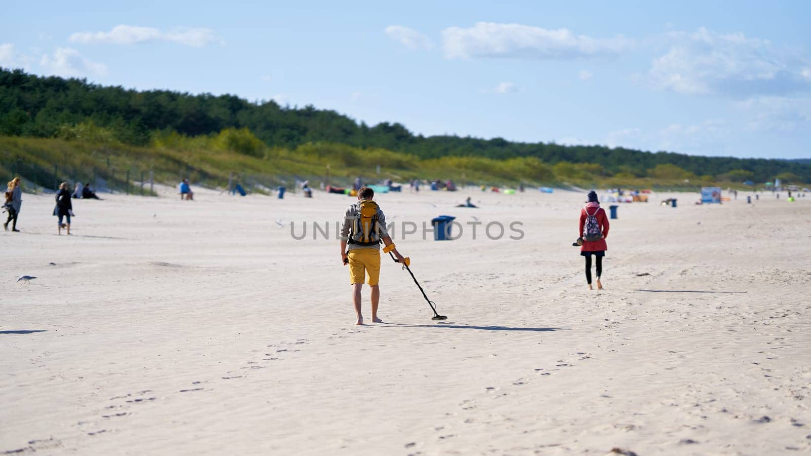 Treasure hunter with metal detector on the beach of Swinoujscie on the Polish Baltic coast
