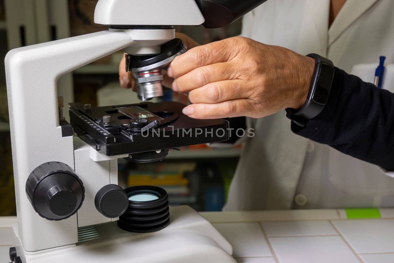Biology lesson. Teacher is using an optical microscope to carry out her lesson.