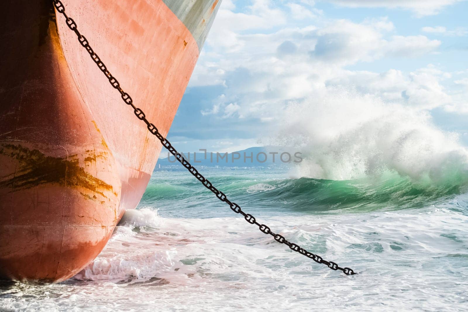 A stranded ship on the shore. Waves are hitting the ship side by side.