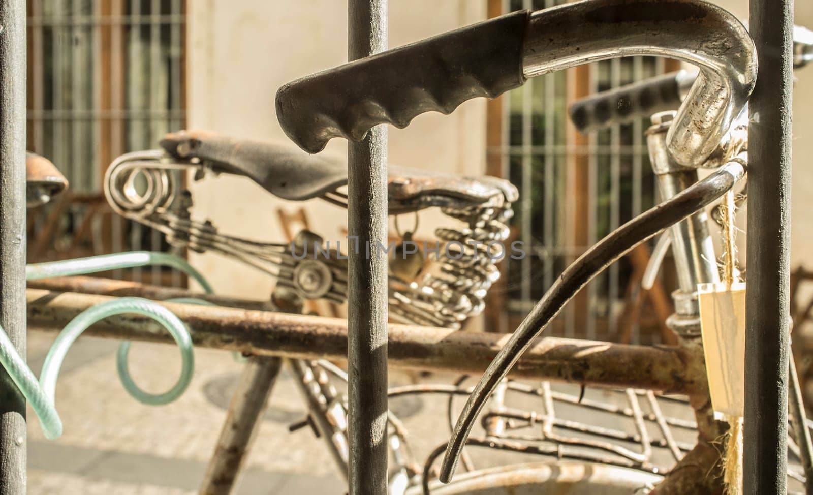 Parked vintage bicycles chained with padlock to window grille house. Selective focus