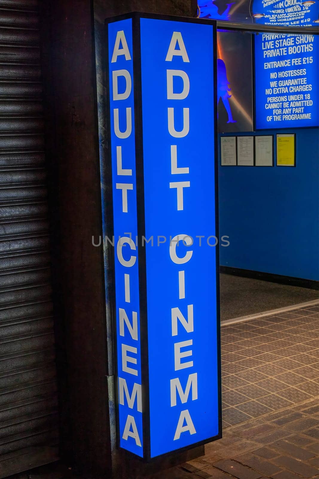 Adult cinema sex shop neon sign advertising a licensed business in the Soho red light district industry, stock image photo