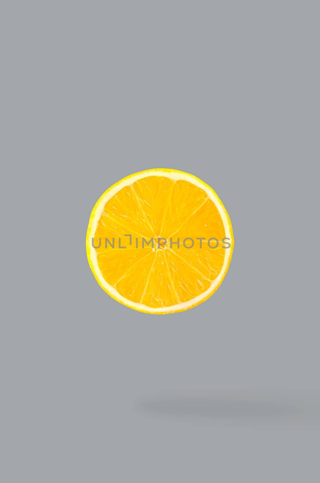 Minimal fruit concept. One slice of lemon with shadow. Illuminating colour fruits on ultimate gray background. Design element. Full depth of field.
