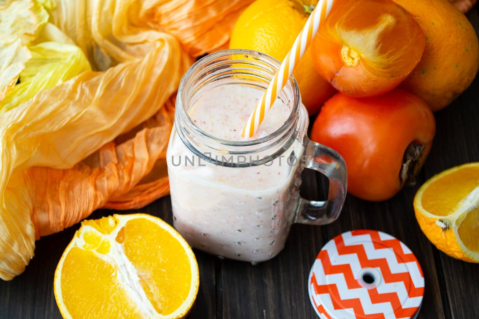 Detox healthy smoothie with persimmon, orange and ginger on a dark wooden table
