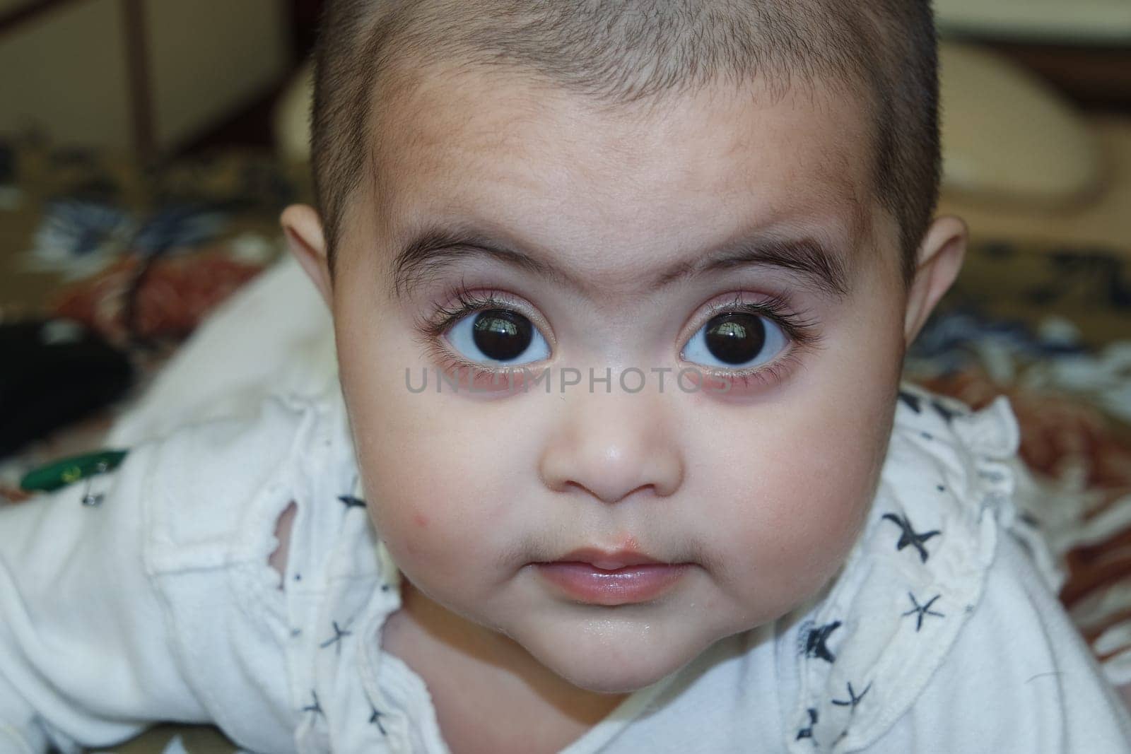 Baby girl with lovely face, big eyes and cute face gesture. Toddler baby making sweet activities