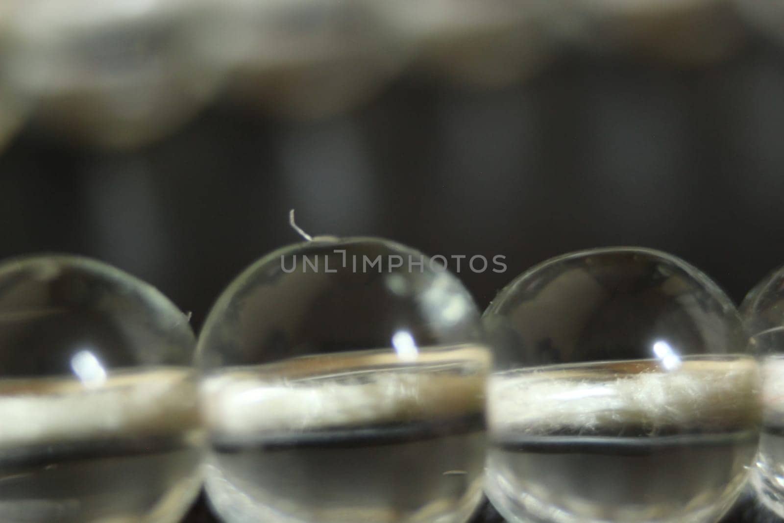 Macro photograph with selective focus of glass shiny prayer beads or rosary with copy space for text. Religion concept of ramadan or Eid for muslims.