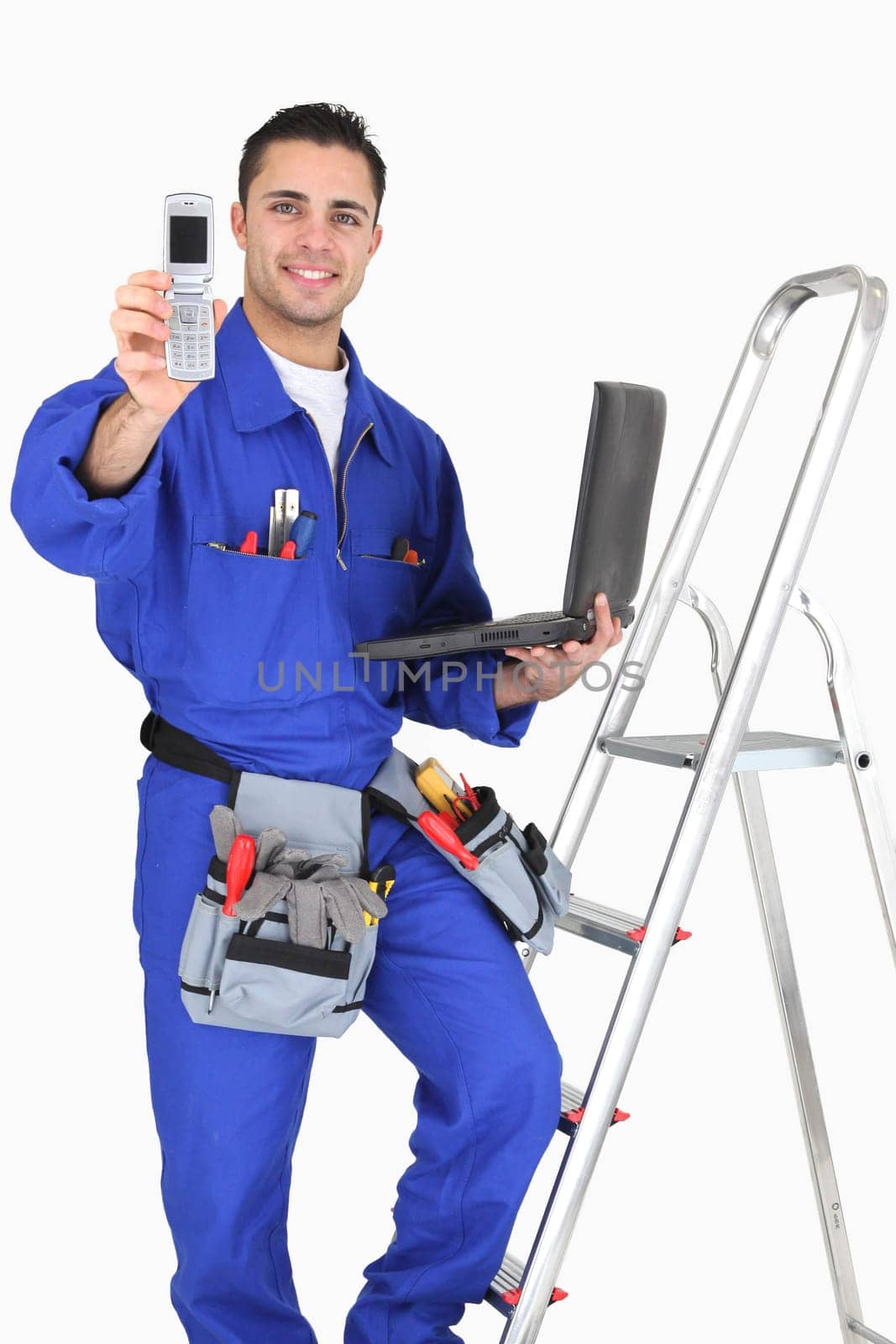Young electrician with a phone and a laptop computer