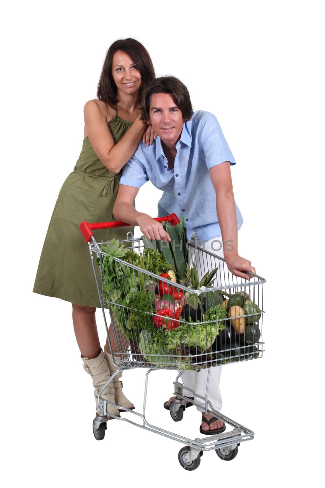 Couple stood with trolley full of vegetables