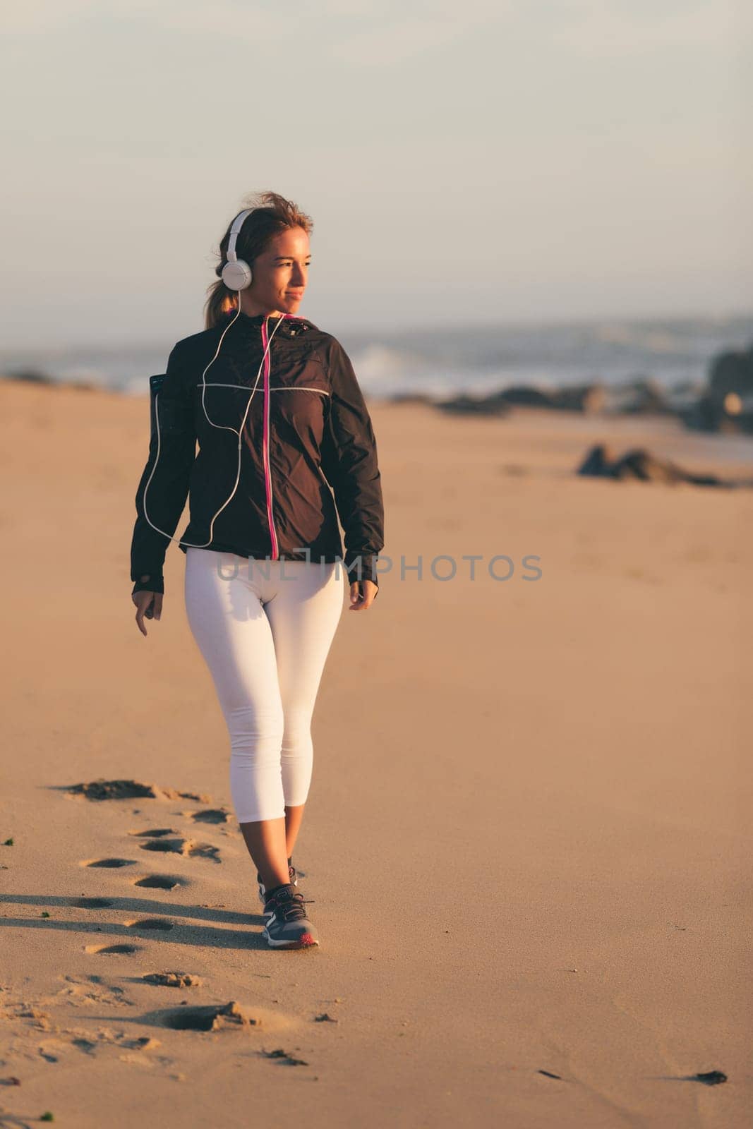 Young beautiful chinese woman exercising at the beach at sunrise/sunset