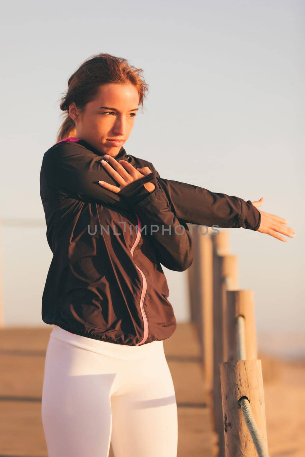 Young beautiful chinese woman exercising at the beach at sunrise/sunset
