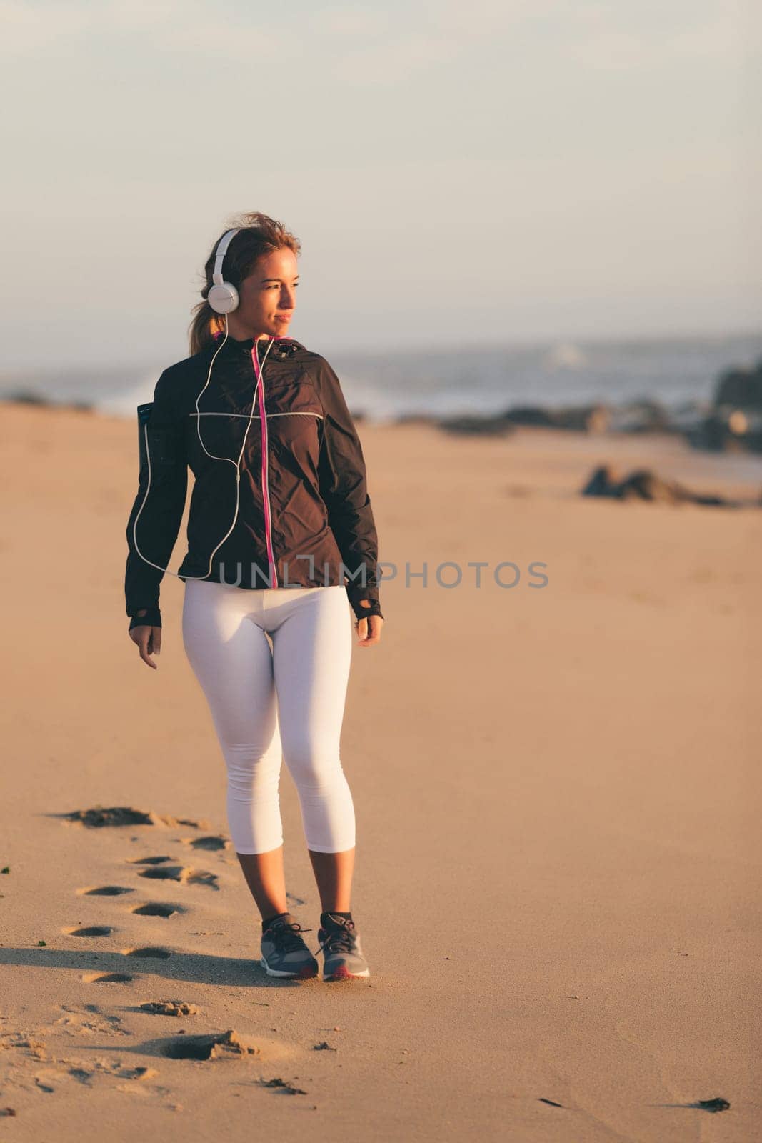 Young beautiful chinese woman exercising at the beach at sunrise/sunset