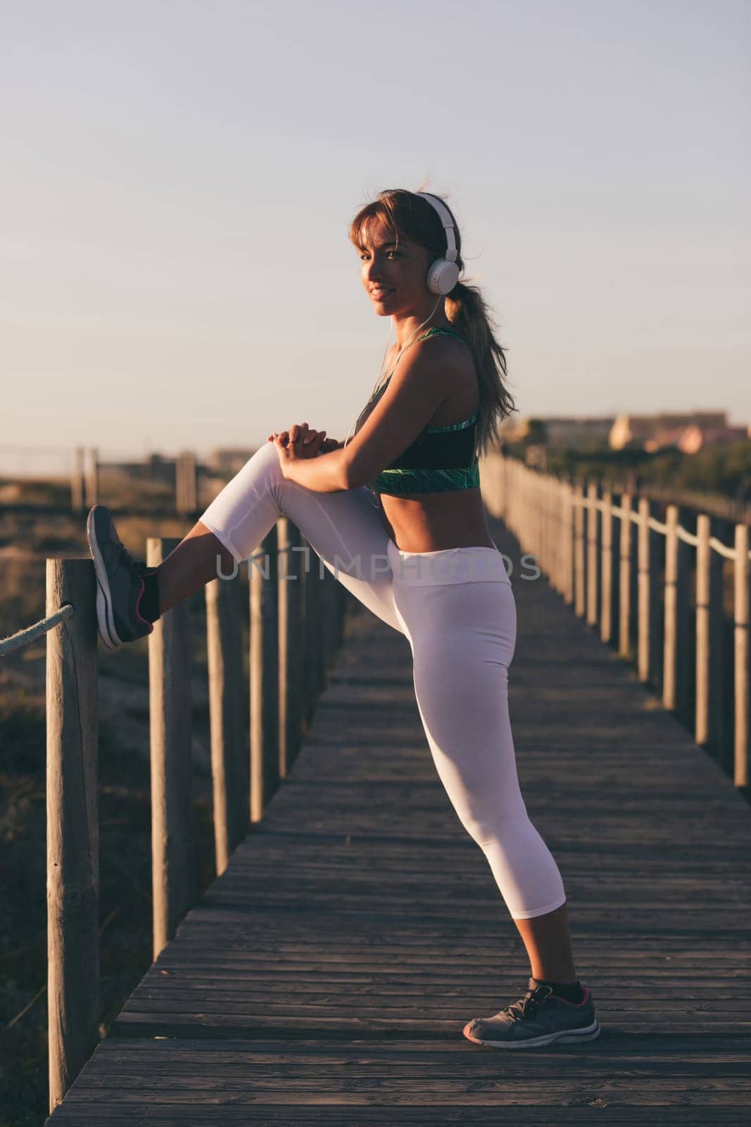Young beautiful chinese woman exercising at the beach at sunrise/sunset