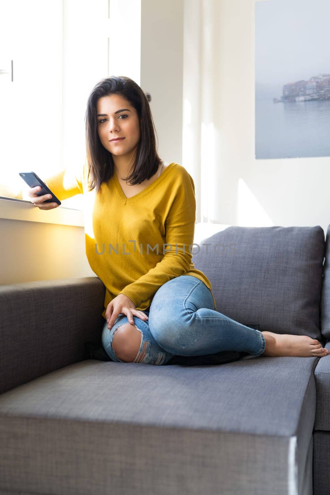 Woman relaxing on couch and making a phone call