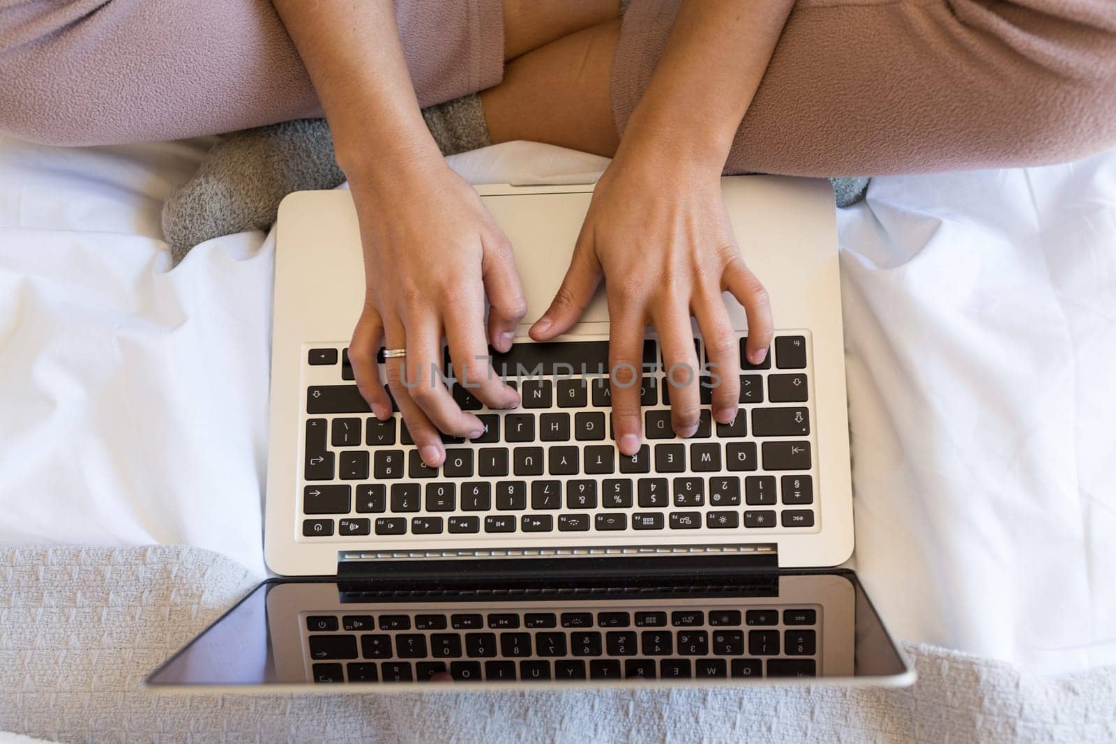 Young woman relaxing with her computer in bed