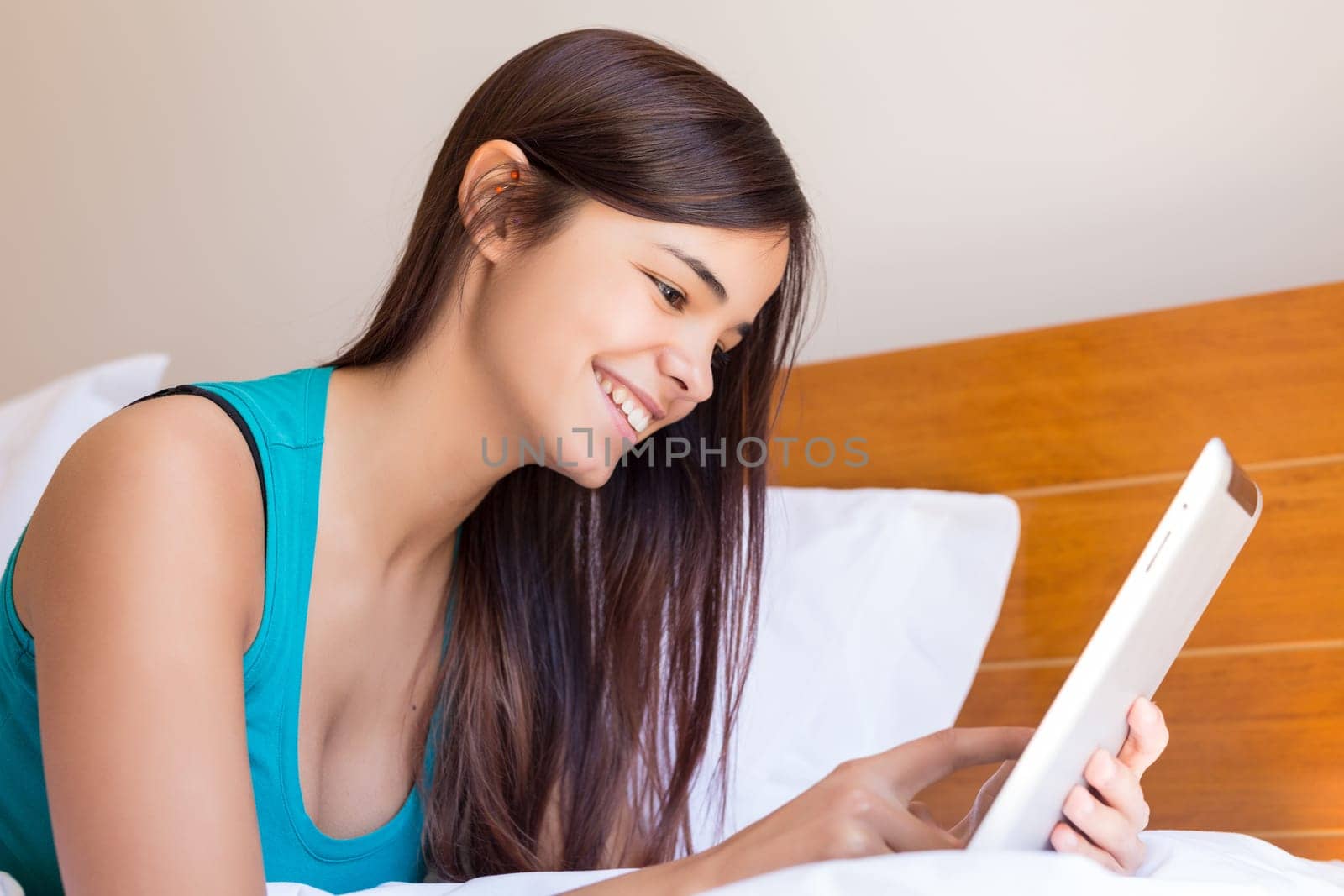 Young woman relaxing with her computer in bed