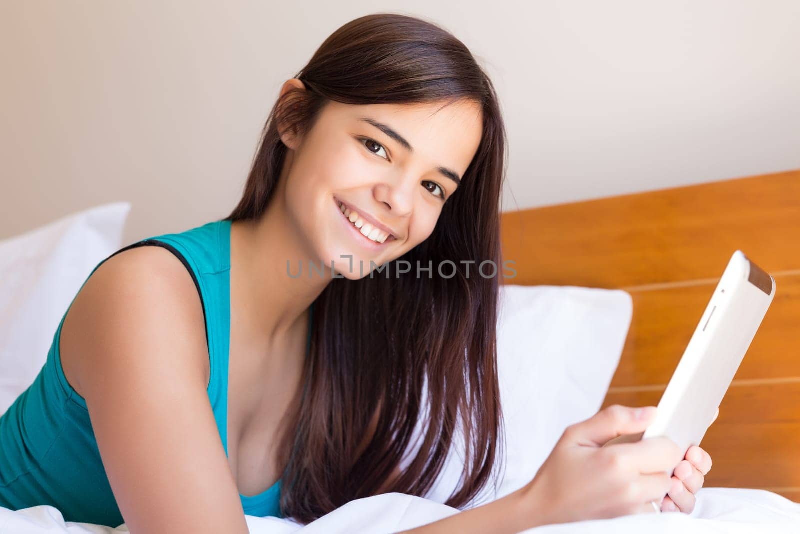 Young woman relaxing with her computer in bed