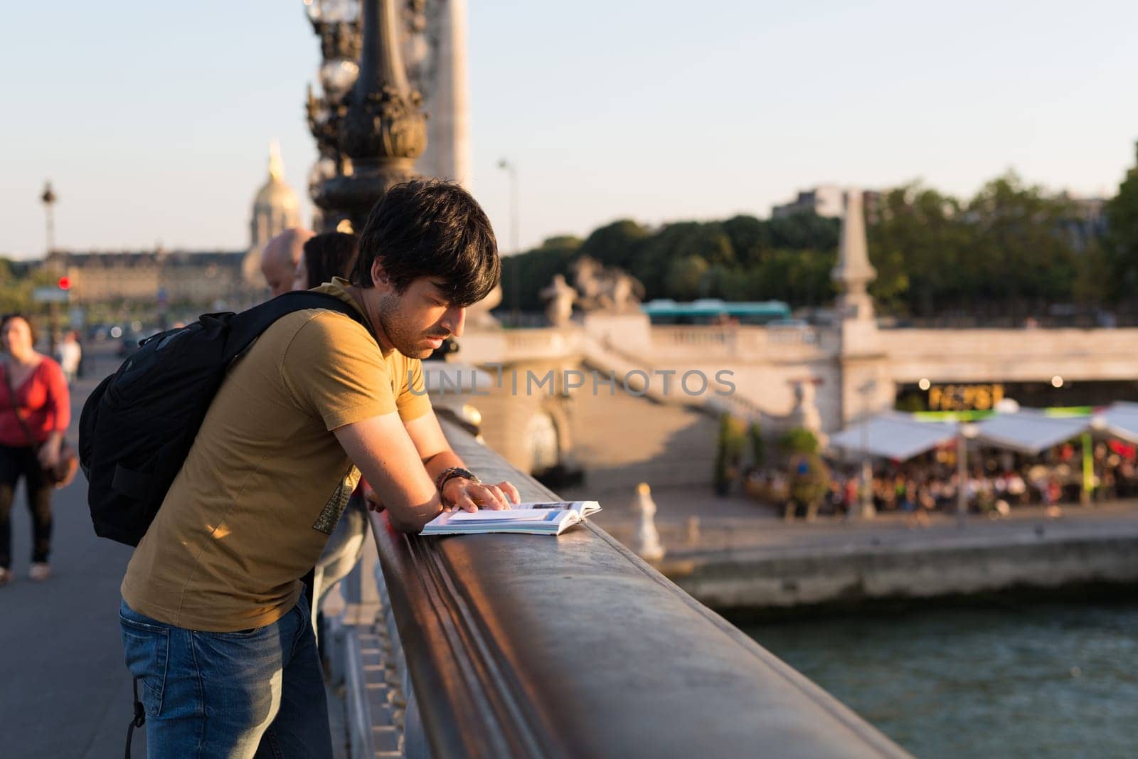 Young man on vacations in Paris, relaxing over the Alexander the 3rd bridge