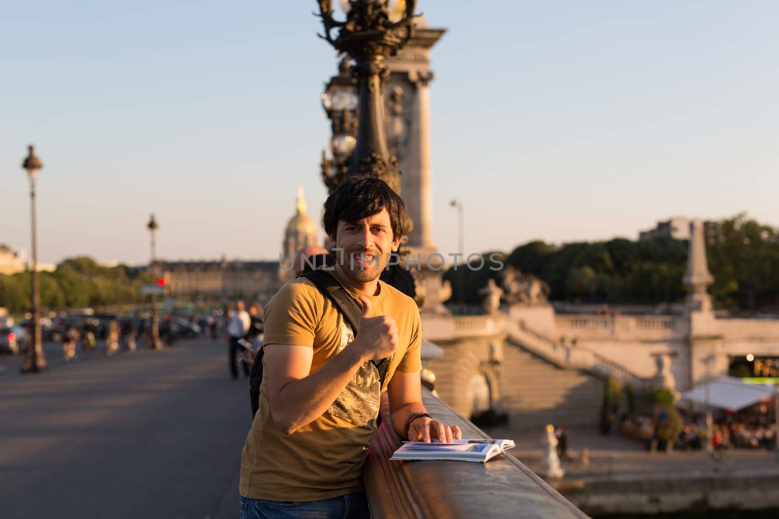 Young man on vacations in Paris, relaxing over the Alexander the 3rd bridge