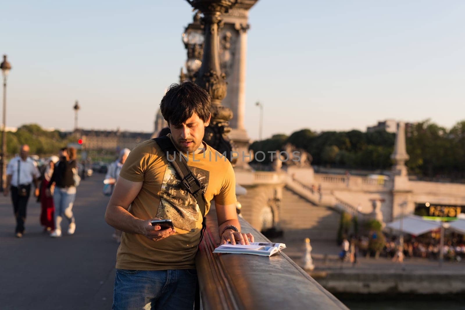 Young man on vacations in Paris, relaxing over the Alexander the 3rd bridge