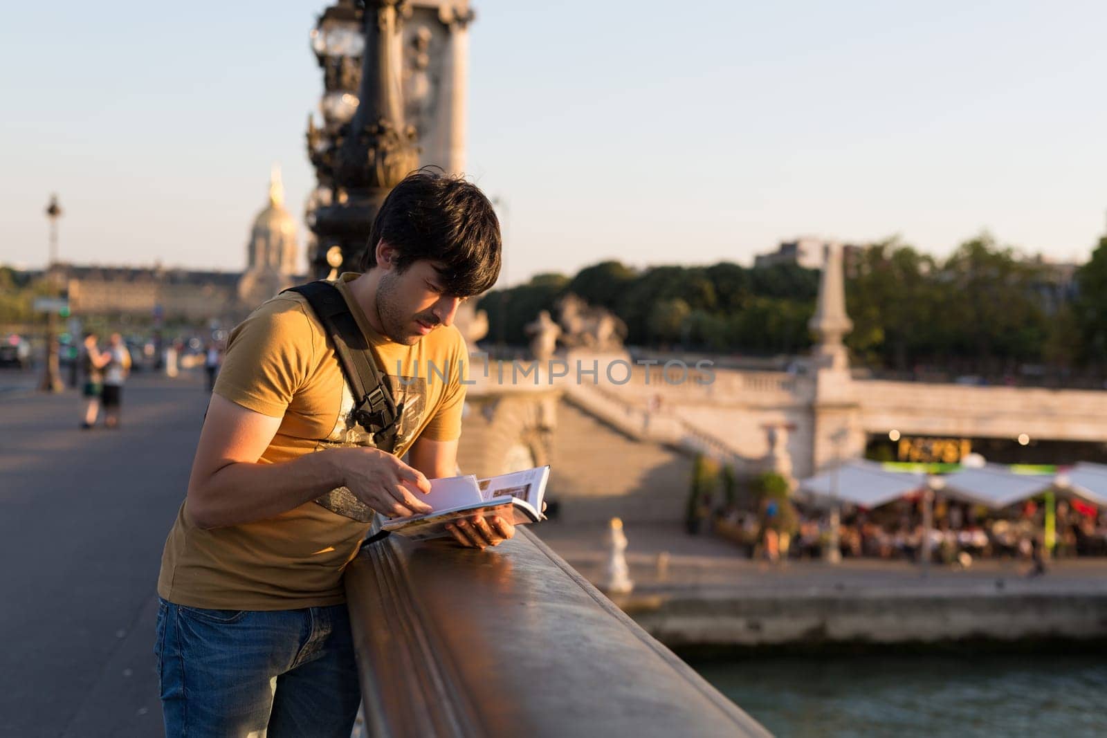 Young man on vacations in Paris, relaxing over the Alexander the 3rd bridge