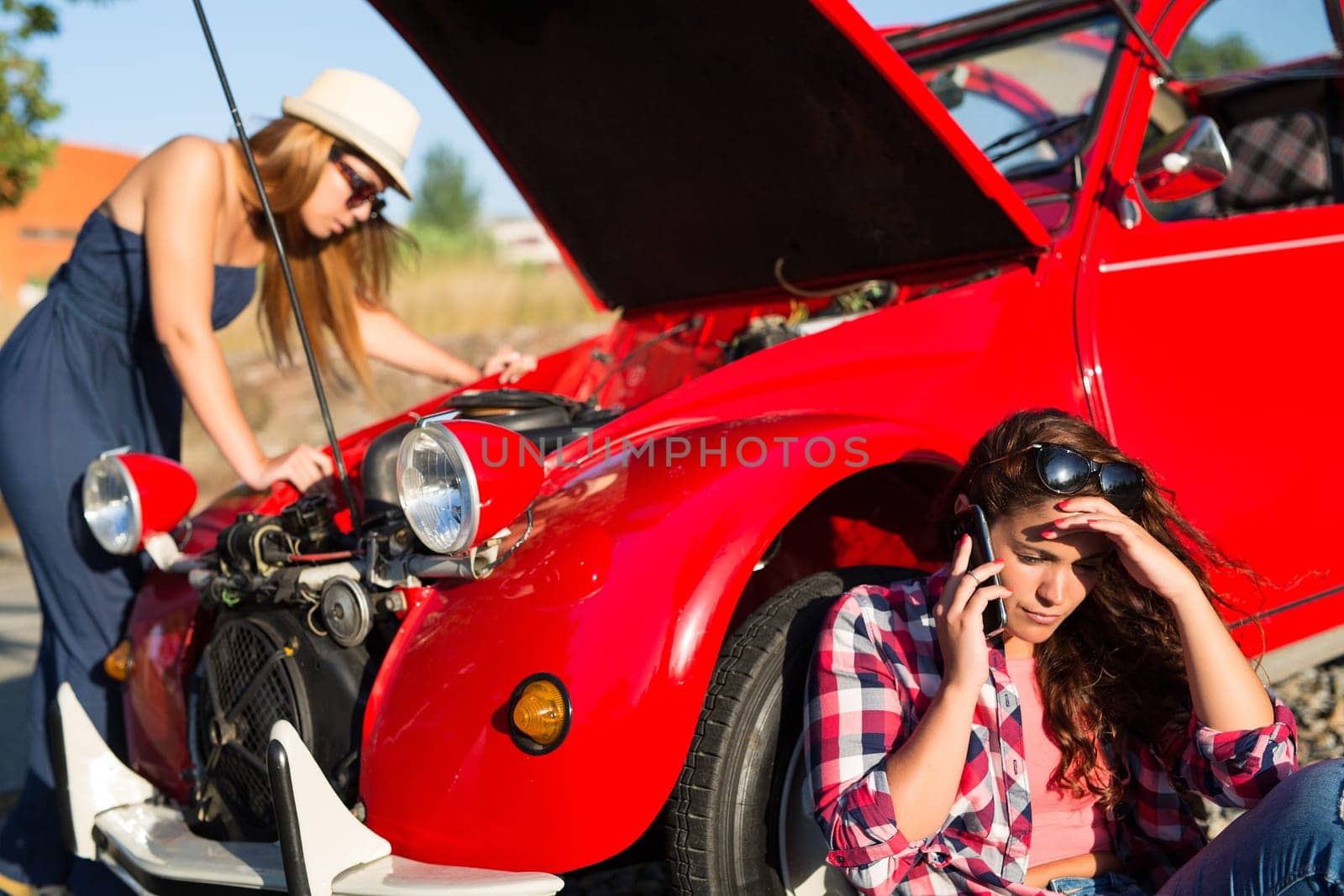 Friends on a roadtrip having a problem with their old car