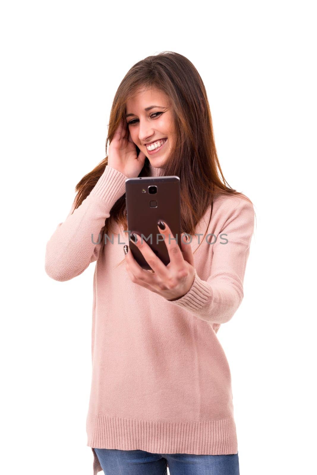 Happy young woman taking self portrait photography through smart phone over white background.