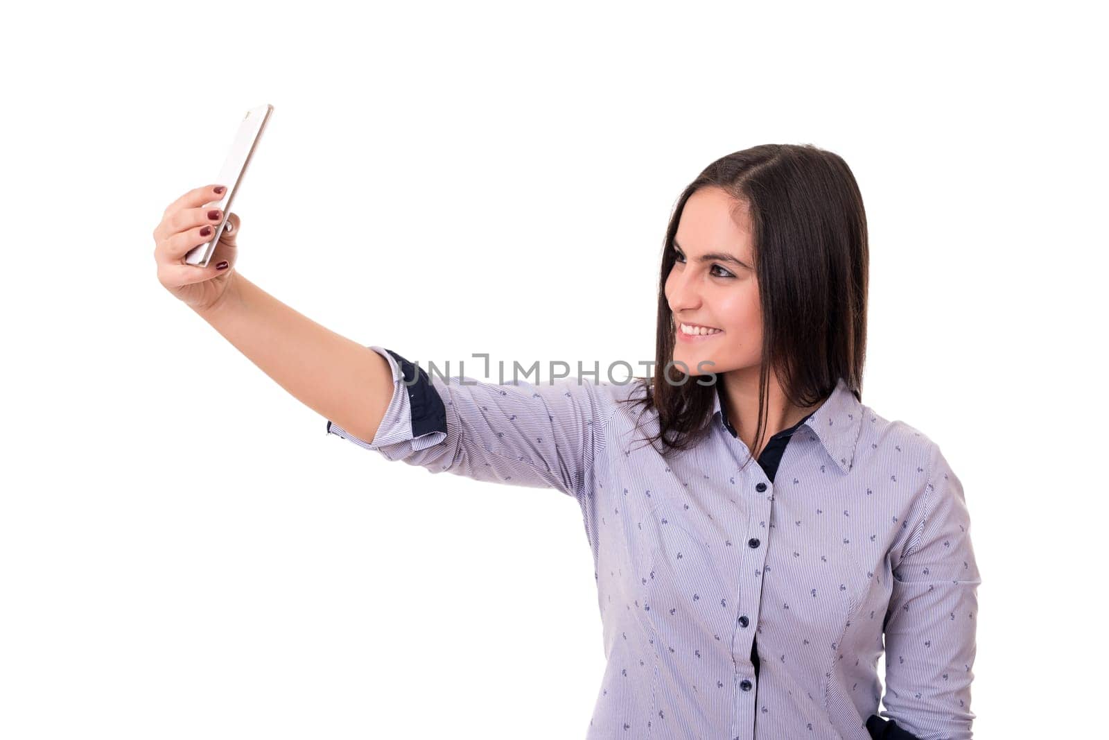 Happy young woman taking self portrait photography through smart phone over white background.