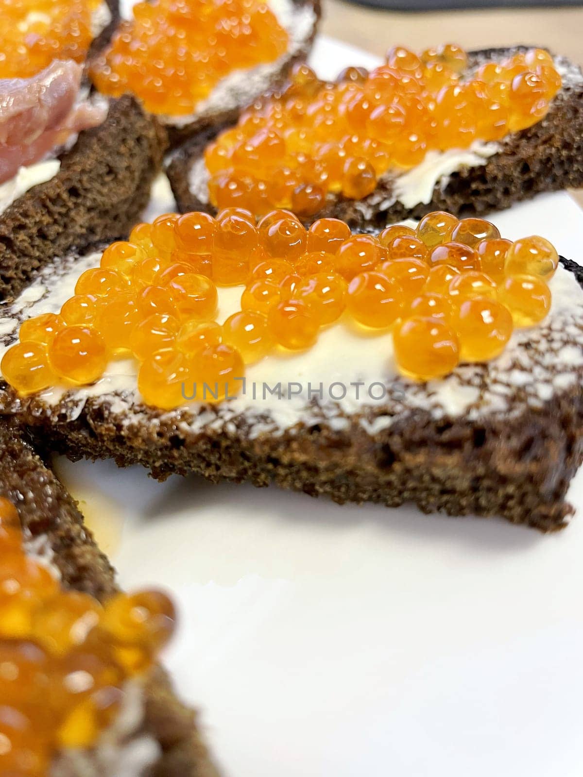 Red caviar on black bread with butter - photo