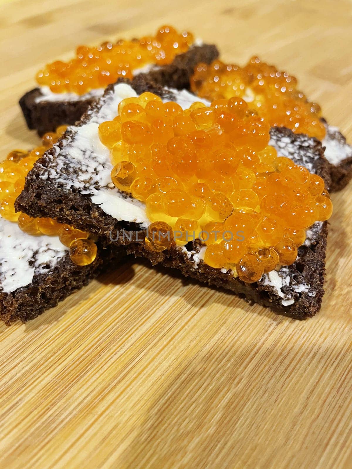Red caviar on black bread with butter - photo