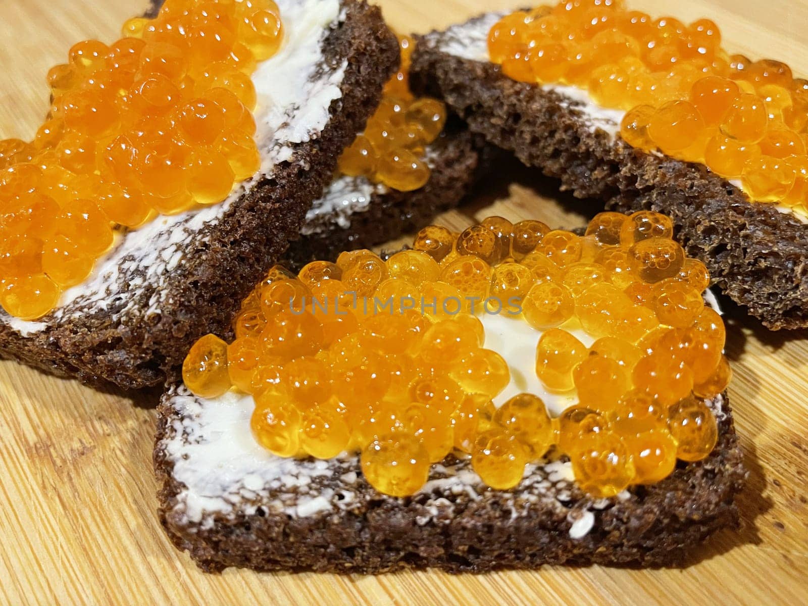 Red caviar on black bread with butter - photo