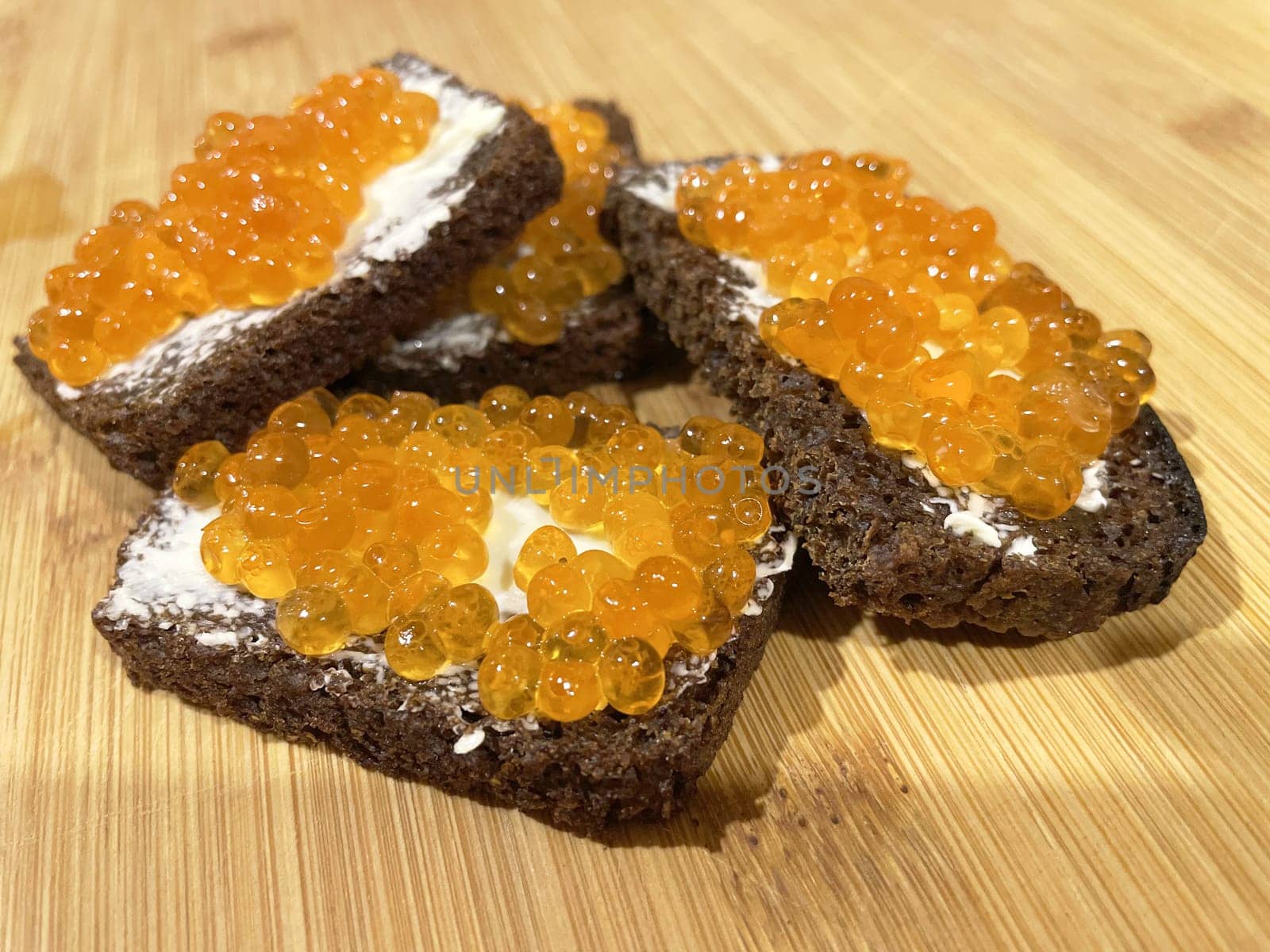 Red caviar on black bread with butter - photo