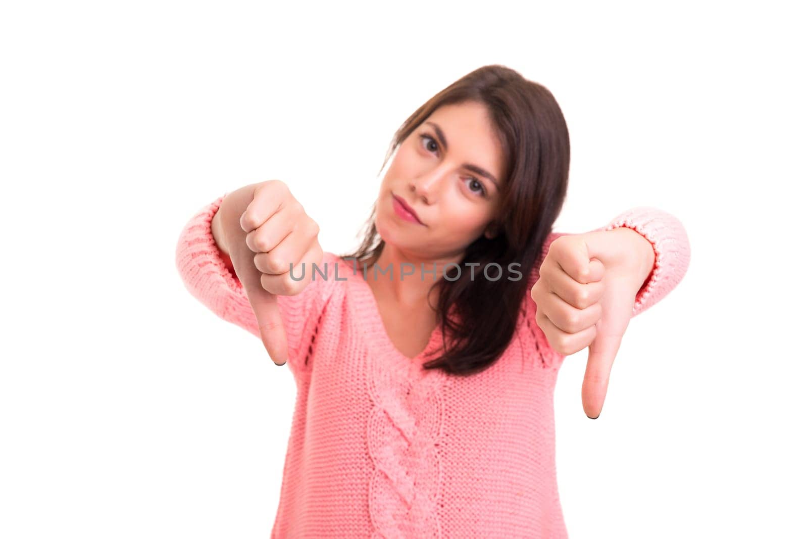 Studio shot of a young woman signaling thumbs down